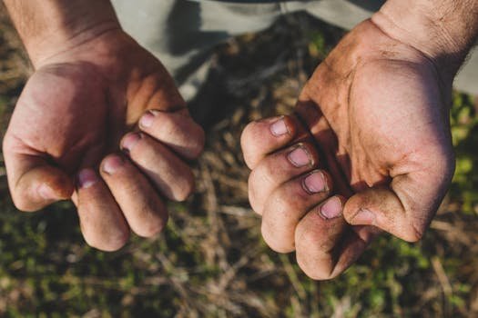 Close-up of a worker's dirty hands, emphasizing labor and effort.