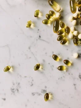 Assorted capsules and pills on a marble surface, perfect for healthcare and pharmaceutical themes.