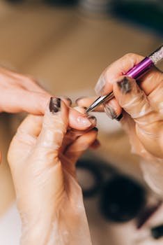 Close-up of a manicurist applying nail polish during a professional salon treatment.