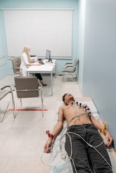 A man undergoing an ECG medical procedure in a clinic under doctor supervision.